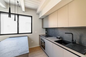 A modern kitchen with a large window, built-in oven, and a black countertop. - SE308 – Senigallia, brand-new two-bedroom apartment with wi-fi and air conditioning (Senigallia)
