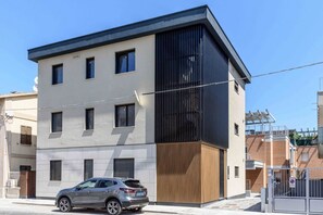 A modern multi-story building with a car parked in front. - SE308 – Senigallia, brand-new two-bedroom apartment with wi-fi and air conditioning (Senigallia)