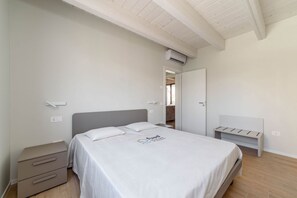 A bedroom with a bed, bedside tables, a wardrobe, and an air conditioning unit. - SE308 – Senigallia, brand-new two-bedroom apartment with wi-fi and air conditioning (Senigallia)
