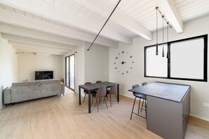 A modern living space with a dining area, a sofa, and a kitchen island. - SE308 – Senigallia, brand-new two-bedroom apartment with wi-fi and air conditioning (Senigallia)