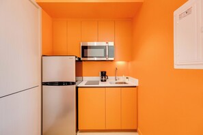 A compact kitchen with a refrigerator, microwave, coffee maker, and sink. - 214 Cook - Loft in the Heart of Old Quebec (Québec)