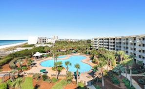 A resort with a large pool, palm trees, and a beach view. - The Crescent 403 (Miramar Beach)