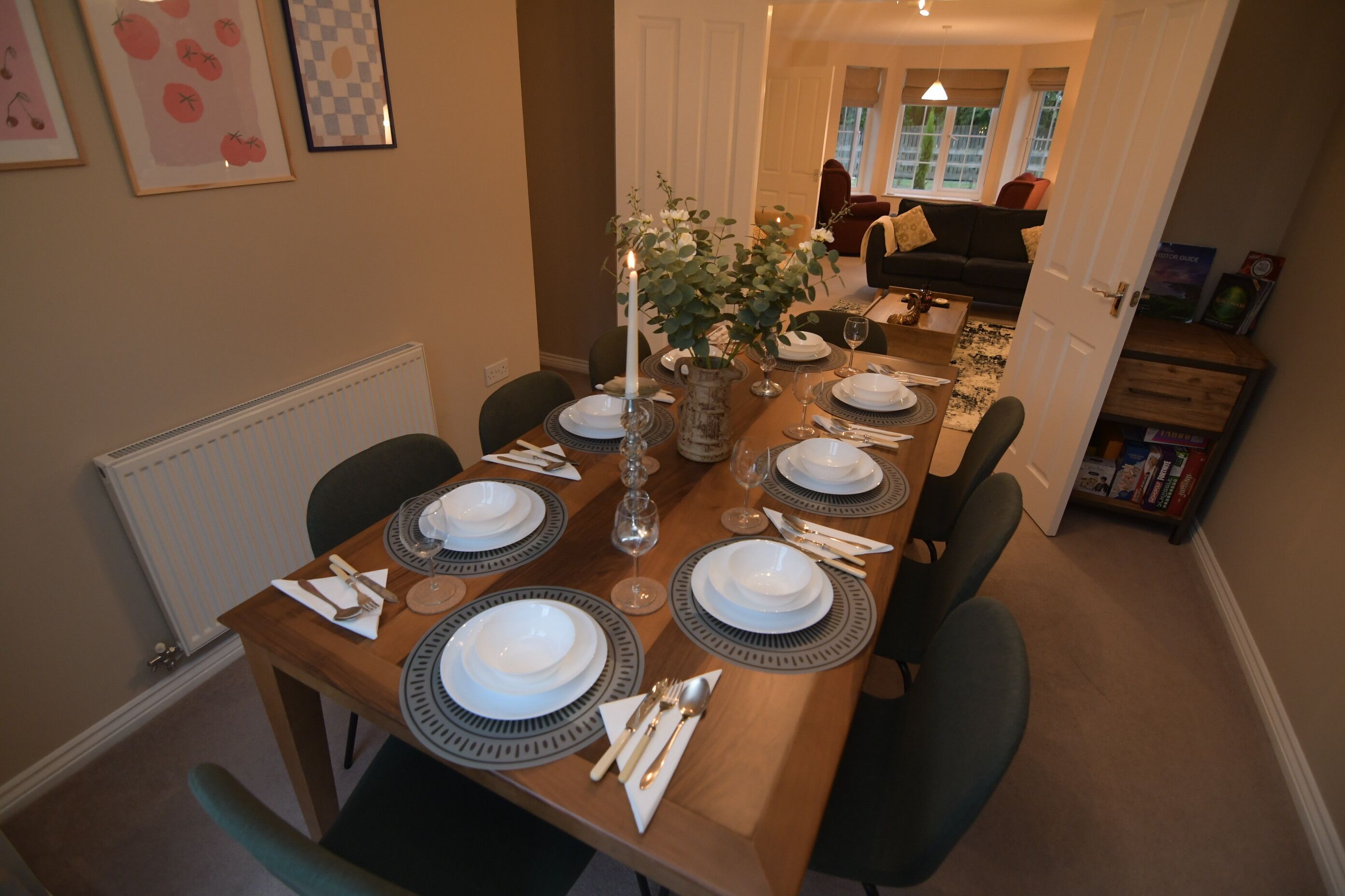 A dining room with a long table set for six, surrounded by chairs.