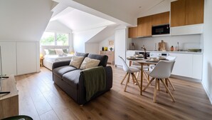 Ein modernes Loft mit Essbereich, Küche und einem gemütlichen Wohnbereich mit Sofa und Esstisch.