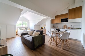 Ein modernes Loft mit Essbereich, Küche und einem gemütlichen Wohnbereich mit Sofa und Esstisch.