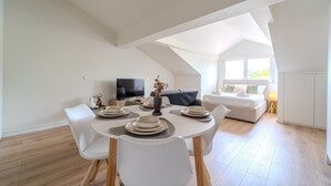 Ein moderner, offener Wohnbereich mit Essplatz, Fernseher und Sofa.
