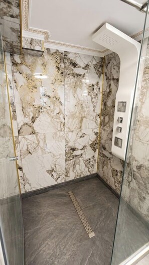 A bathroom with marble walls and a shower area. - The Golden Suite | Premium Stay (București)
