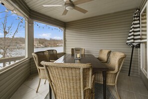 A covered patio with wicker chairs, a table, and a ceiling fan. - Brush Creek Retreat With Boat Slip (Sunrise Beach)