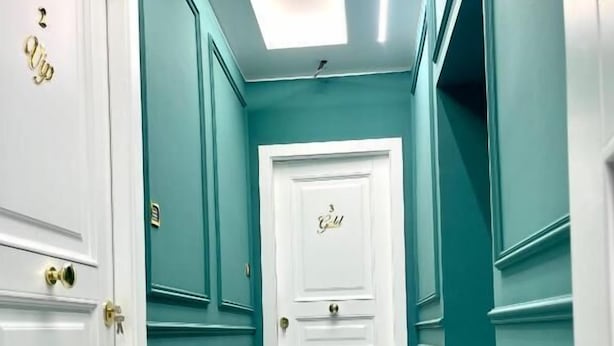 A hallway with white doors and teal walls, leading to a room with a white door. - Al Binario di Napoli (Naples)