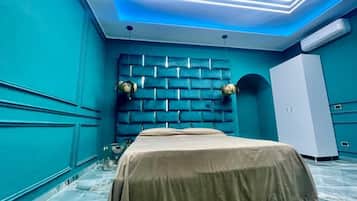 Ein Zimmer mit einem Bett, einem Wandpaneel als Kopfteil, einem Kleiderschrank und einer Decke mit LED-Beleuchtung.