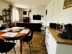 Eine moderne Küche mit Holztresen, einer Kaffeemaschine und einer Mikrowelle.