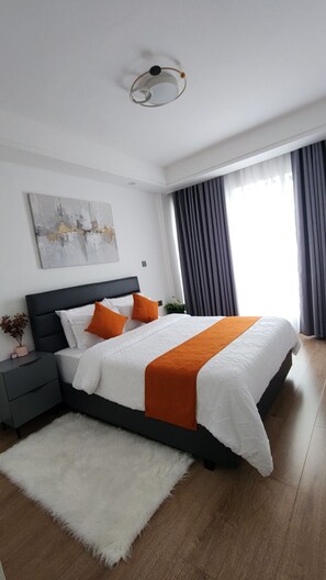 Une chambre à coucher moderne avec un lit, une table de chevet et un tapis blanc.