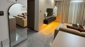 A modern living room with a dining area, a large mirror, and a unique ceiling light fixture. - Modern 1-Bedroom in Kilimani  Pool, Gym, Fast Wi-Fi, Near Yaya & CBD (Nairobi)