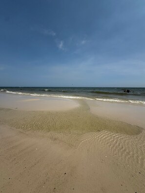 Ein Strand mit klarem Himmel und ruhigem Wasser.
