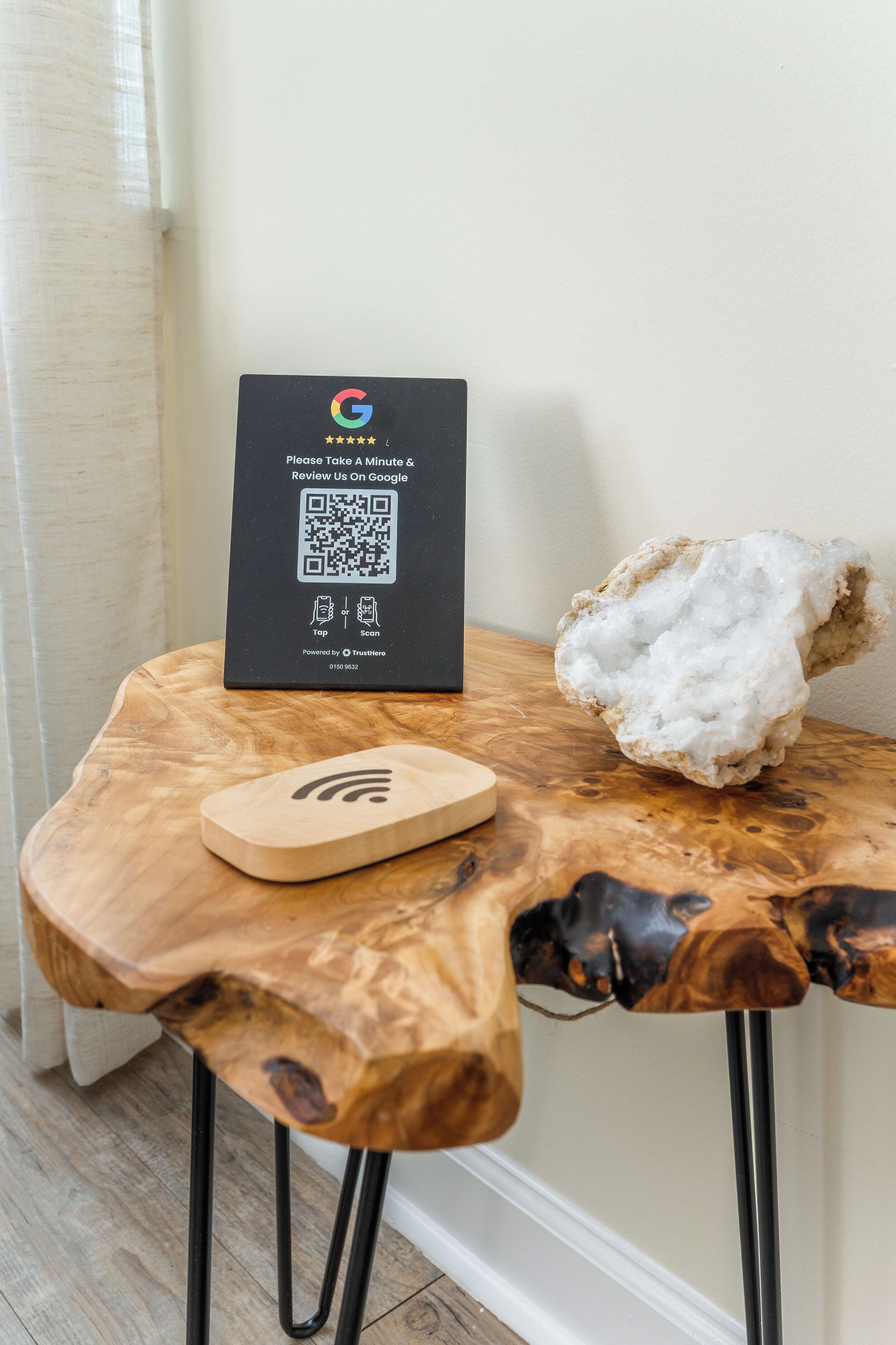 A wooden table with a QR code, a smartphone, and a quartz crystal.