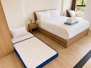 Ein Schlafzimmer mit einem Bett, einem Nachttisch und einem Fenster.