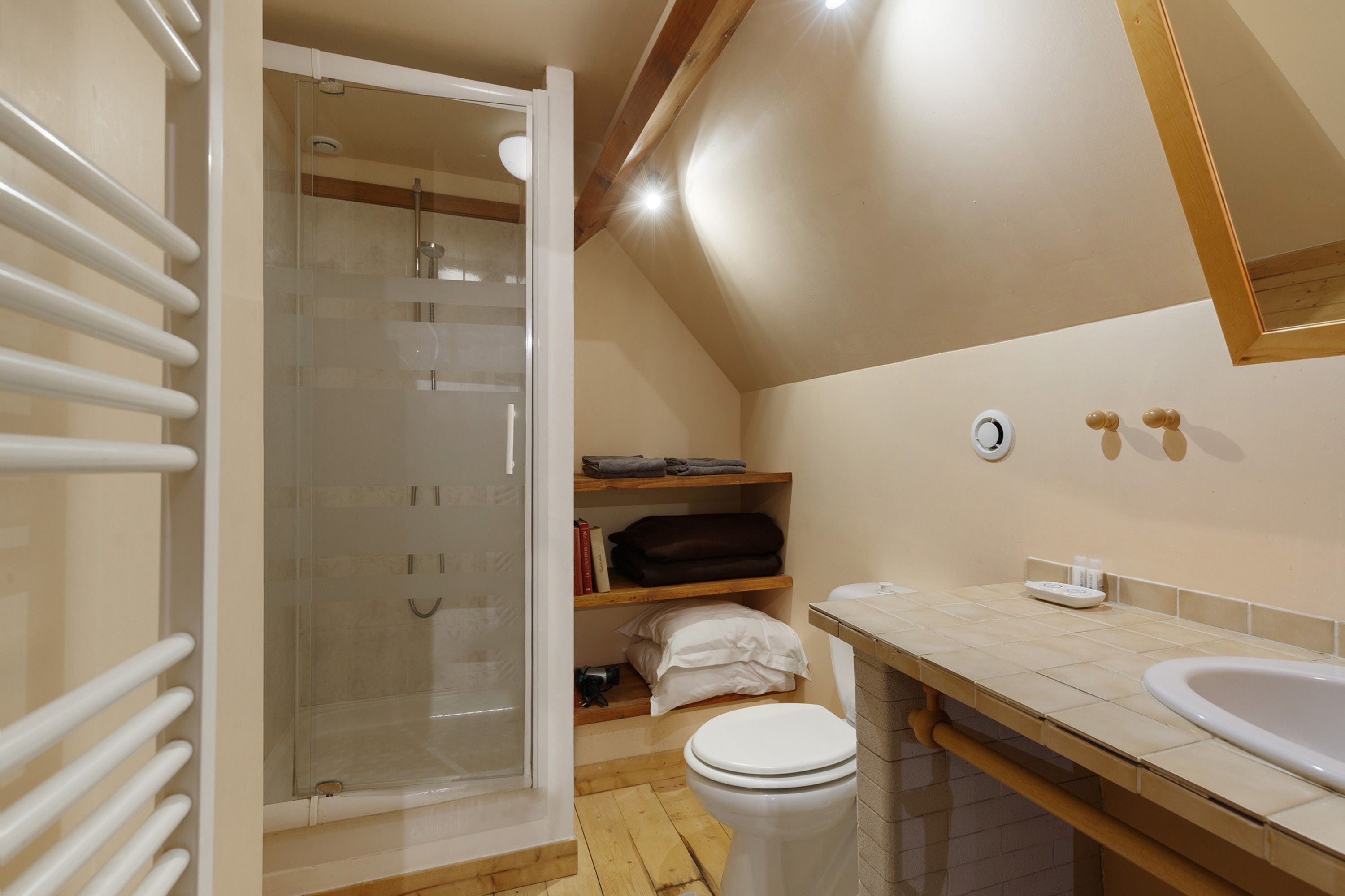 Ein Badezimmer mit einer Duschkabine, Toilette, Waschbecken und Spiegel.