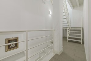 Una escalera con barandillas blancas y un cuadro en la pared.