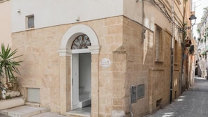 A building with a stone facade, a white door with an arched entrance, and a sign indicating a bed and breakfast. - Star Suite Superior by BarbarHouse (Taranto)