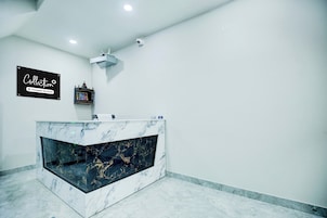 A reception desk with a marble top and a built-in aquarium.