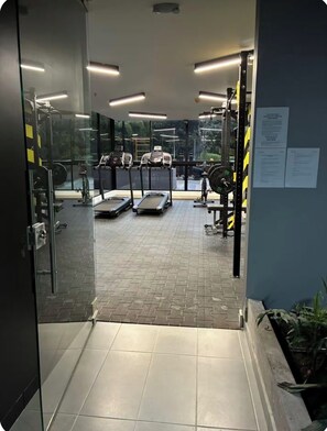 Ett gym med löpband, en motionscykel och utrustning för styrketräning.