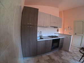 A kitchen with a built-in stove, oven, and sink. - Casa Aura Mare, Orosei (Sardegna)