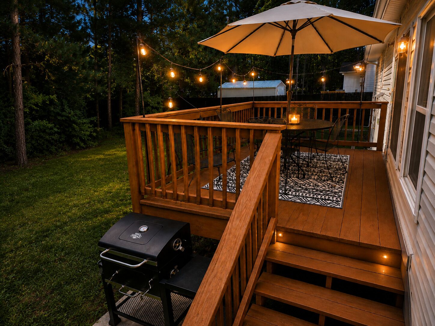A wooden deck with a barbecue grill, outdoor seating, and string lights.