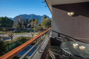 Ein Balkon mit Bergblick, einem Tisch und Stühlen sowie einem Geländer.