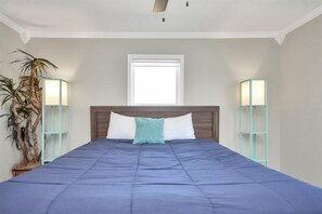 A bedroom with a large bed, a window, and two bedside lamps. - Holds 8 · Private Pool,  3BR/2BA Peacock Horse Beach nearby Outside of city Life (Galveston)