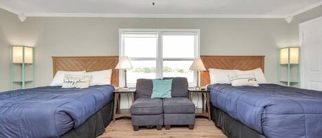 Hotellihuone, jossa on kaksi sänkyä, sohva ja kattotuuletin.