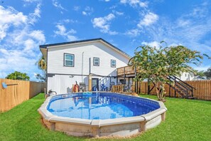 A two-story house with a backyard swimming pool, a wooden deck, and a fenced area. - Holds 8 · Private Pool,  3BR/2BA Peacock Horse Beach nearby Outside of city Life (Galveston)