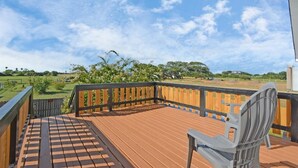 Eine Holzterrasse mit Blick auf eine grüne Landschaft und Bäume.