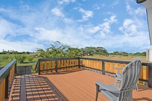 Eine Holzterrasse mit Blick auf eine grüne Landschaft und Bäume.