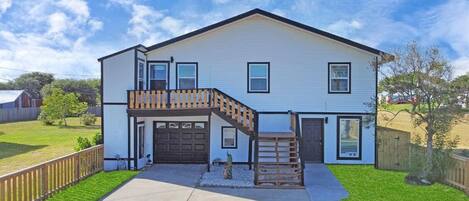A two-story house with a front porch, a garage, and a small front yard.