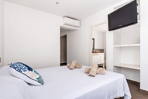 A hotel room with a bed, a television, a wardrobe, and a bathroom visible through an open door. - Magdalena 3 bedroom villa, Cala Blanca (Cala Blanca)
