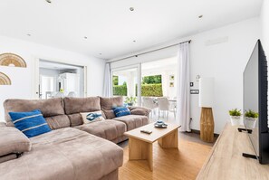 A modern living room with a sectional sofa, a coffee table, and a TV.