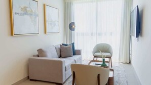 A modern living room with a sofa, armchair, coffee table, and artwork on the wall. - Furnished 2 Bedroom Apartment in Panama (Panamá)
