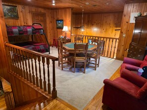 A wooden interior with a pool table, red armchair, and bunk beds. - Judges Hilltop - Highlands, NC (Highlands)