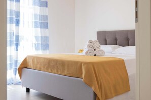 A hotel room with a bed, a headboard, and a window with curtains. - Appartamento "Isola di Maraone" (Carini)
