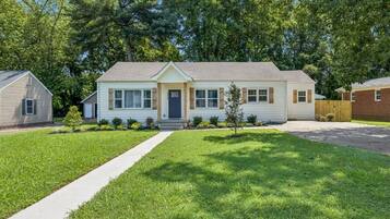 A two-story house with a front porch, a driveway, and a well-maintained lawn.