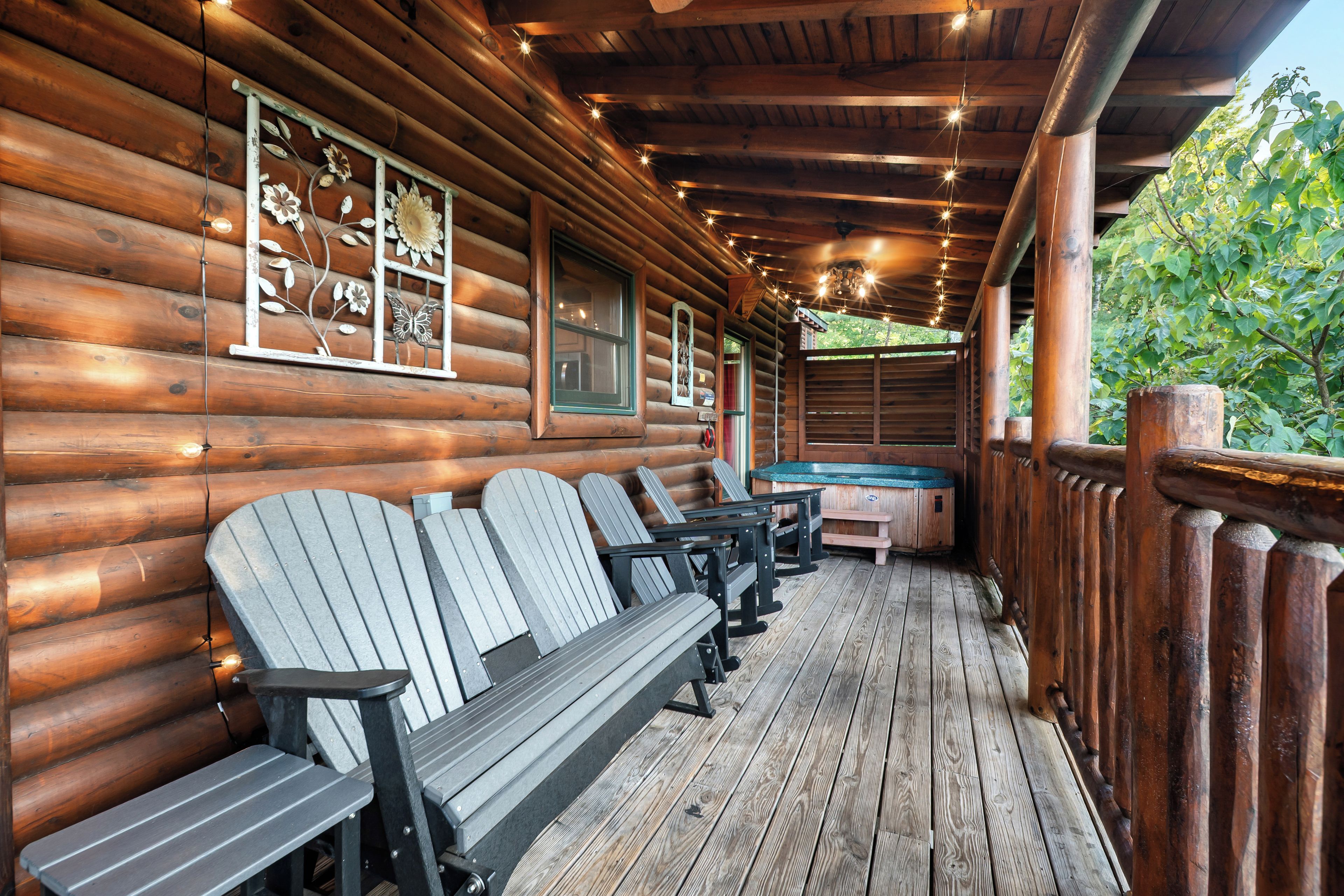 Une cabane en rondins avec une véranda, des bancs en bois et un jacuzzi.
