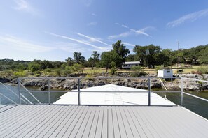 A wooden dock extending into calm water with a clear sky above.
