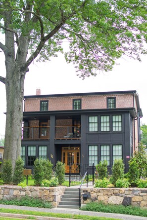 A two-story building with a brick facade, large windows, and a stone foundation.