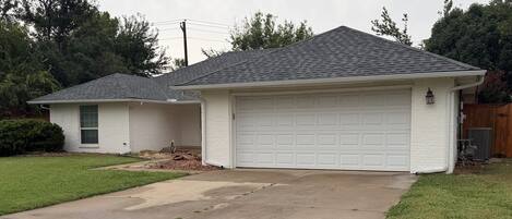 Ein Wohnhaus mit Garage, Auffahrt und Rasen.