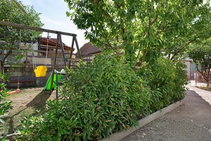 A garden area with a swing set, a bench, and a hedge. - Les bleuets - at Rosine and Pierre's, Alsace charm near Scherwiller vineyards (Châtenois)