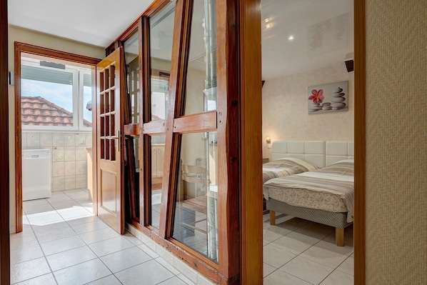 Una habitación de hotel con cama, baño y vistas al exterior.