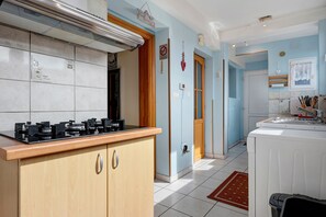 A kitchen with a stove, cabinets, and a tiled backsplash.