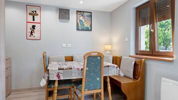 Un comedor con una mesa, sillas, un banco y obras de arte en las paredes.