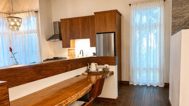 Eine moderne Küche mit Holzschränken, einem Edelstahlkühlschrank und einer Holzausziehtafel.
