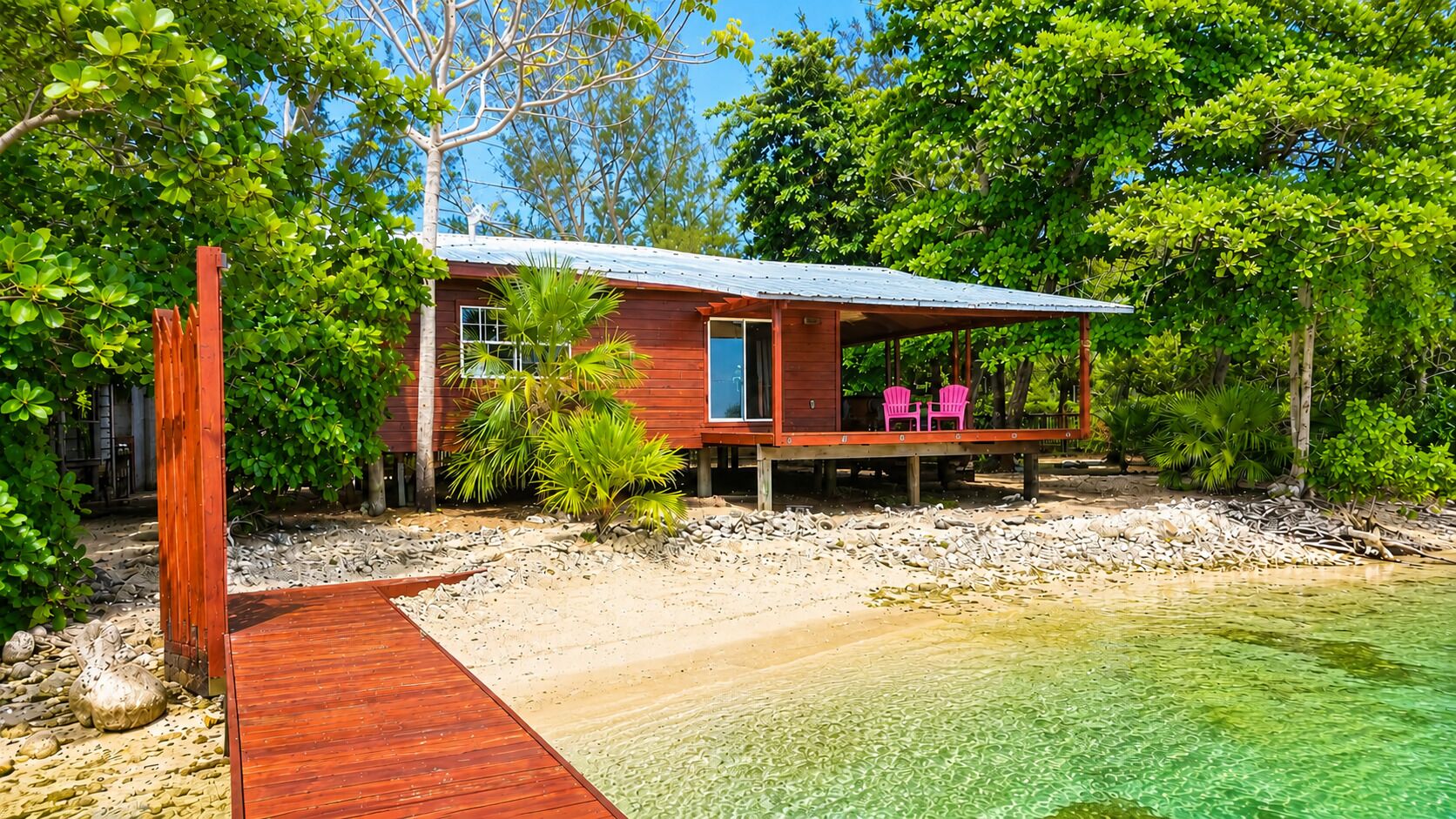 Una casa de madera con porche, una pequeña terraza y una vista despejada del agua.